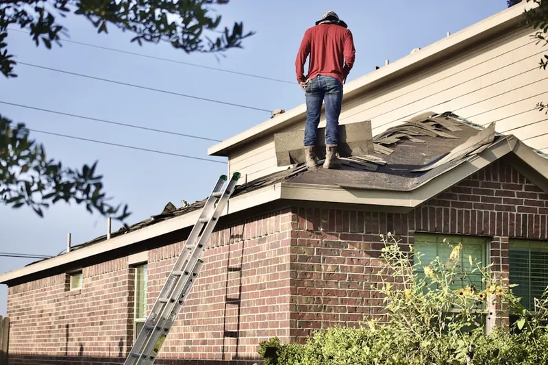 Professional roofer working on a residential roof in Sanger